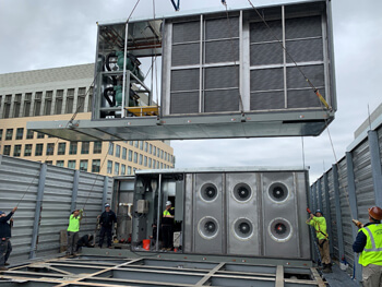 Employees installing HVAC equipment at a large corporate client facility